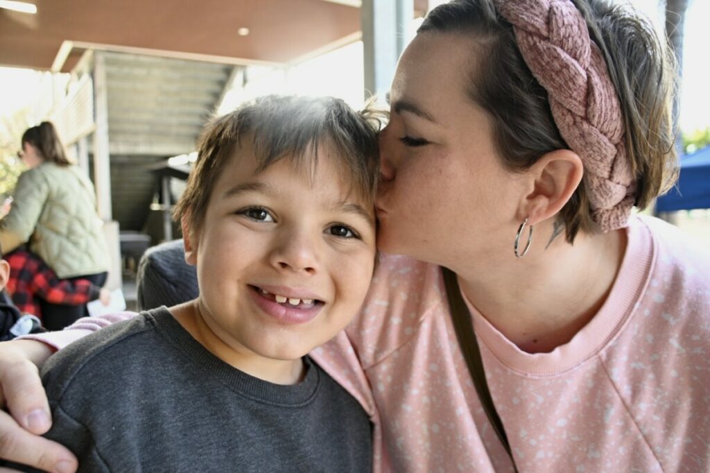 mother embracing her smiling son at San Diego Cooperative tuition-free charter school