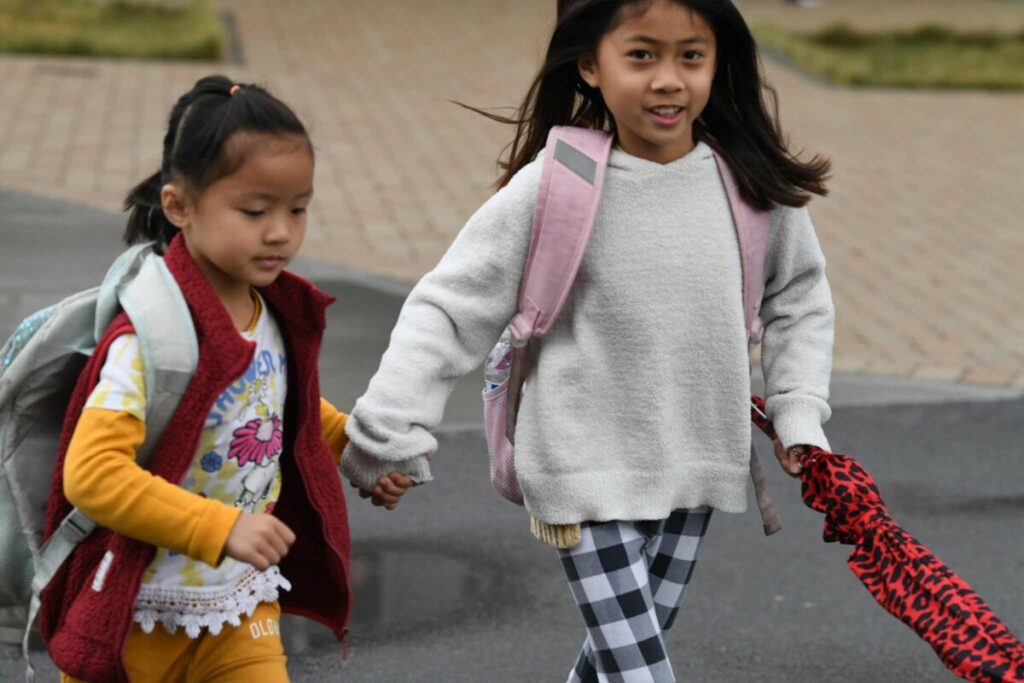 two San Diego Cooperative Charter School tuition-free TK-8 students walking outside hand in hand 