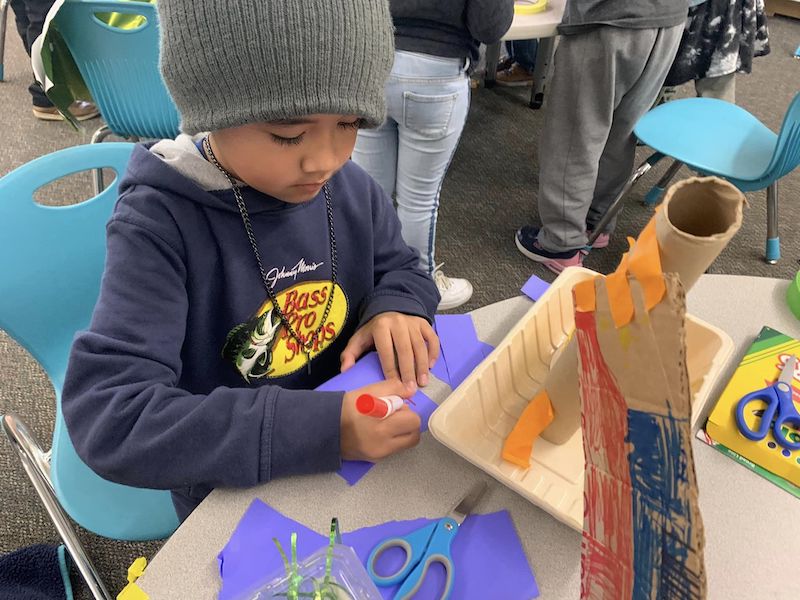 student at San Diego Cooperative Charter School working on a craft project at a table